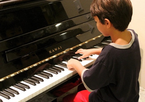 一人でピアノの練習に励む少年
