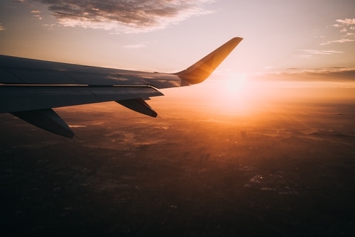 飛行機の窓から見える翼と夕日