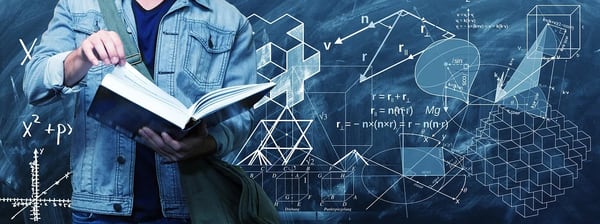 数学の公式が並ぶ黒板と本を読む男性