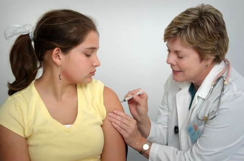 女性医師から予防接種を受ける女性
